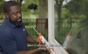DTE employee sealing windows with caulk